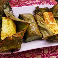 A picture of Spicy paneer steamed in banana leaf wrap.