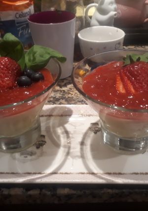 Una foto de Panacotta chocolate blanco con coulis de albahaca y frutos rojos