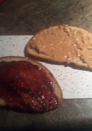 A picture of peanut butter and jelly on sunflower seed bread.