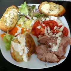A picture of My Garlic Lamb Salad with jacket Potato, tomato, lettuce, Feta cheese.