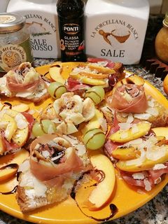 A picture of Bruschetta with Figs Wrapped in Prosciutto and with Peaches on Burrata and Bresaola.