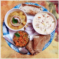 A picture of Potato gravy, kheer, beans and carrots dry bhaji paratha and papad.