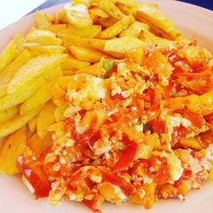 A picture of Chips and egg sauce with veggies.