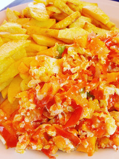 A picture of Chips and egg sauce with veggies.