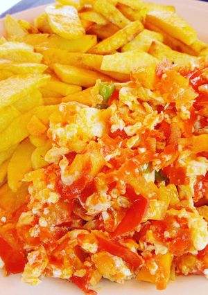 A picture of Chips and egg sauce with veggies.