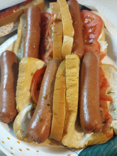 A picture of Hotdogs, with Tomato and Chives.