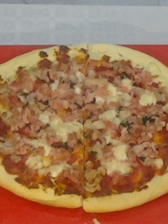 Una foto de Pizza casera con un toque de albahaca