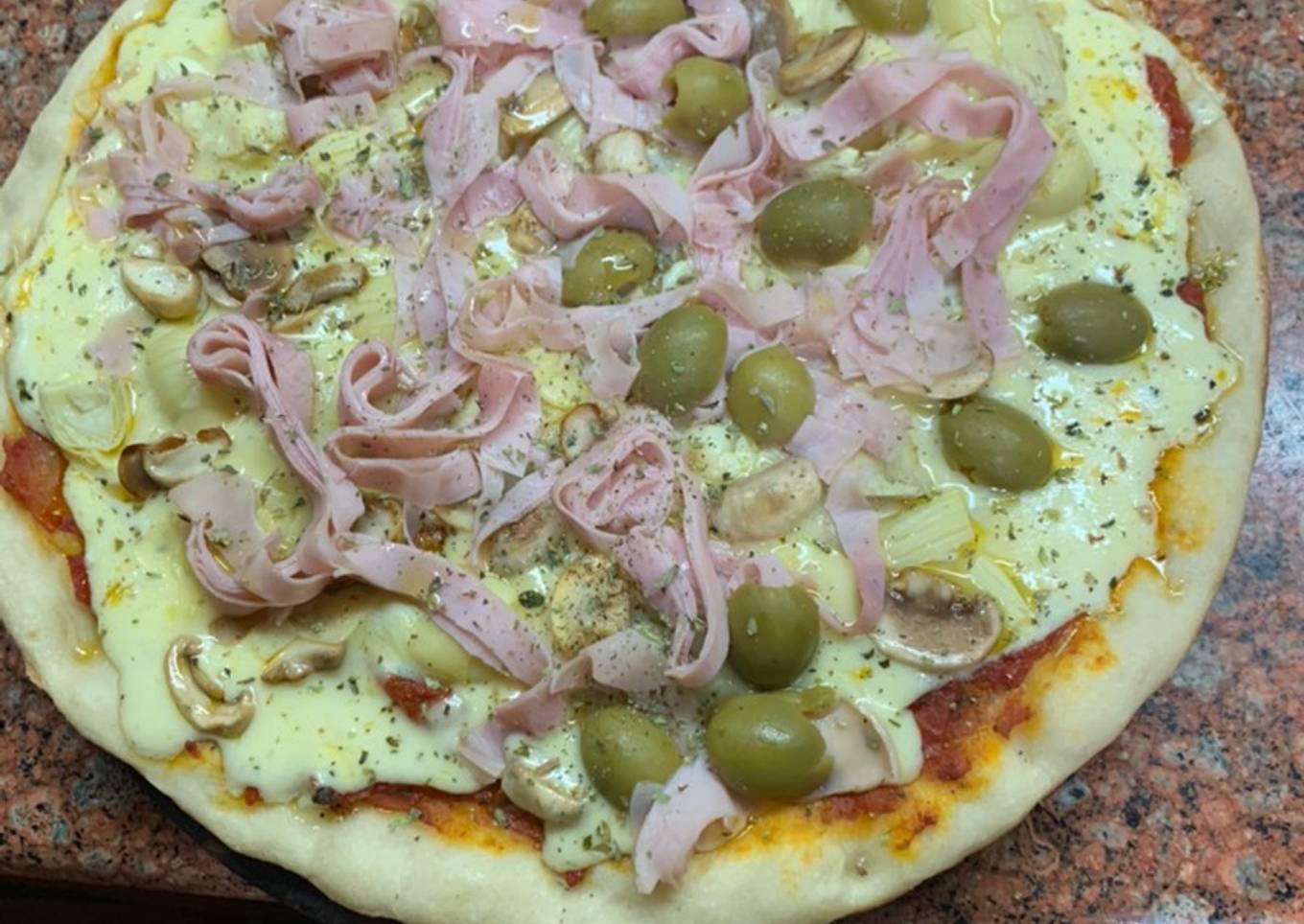 Pizza con alcachofas, champiñones, jamón y aceitunas para no extrañar en cuarentena