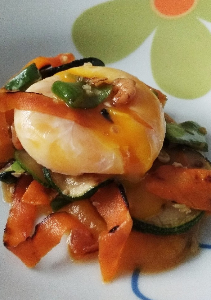 Una foto de Yema de huevo poché sobre puré de calabaza, verduritas y gambas