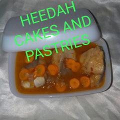 A picture of Fish pepper soup garnished with carrot.