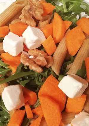 Una foto de Macarrones integrales con rúcula, zanahoria, queso feta y nueces