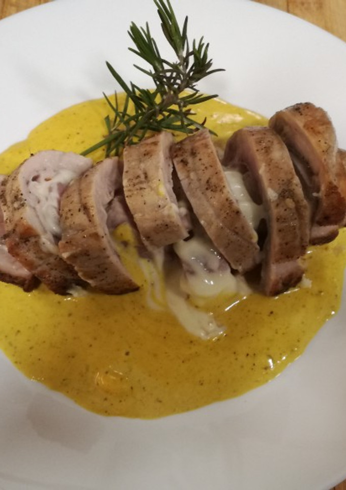 Una foto de Solomillo de cerdo relleno de York y queso con salsa de queso