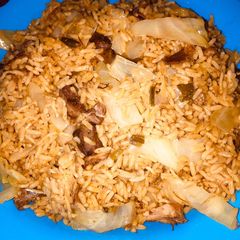 A picture of Jollof rice with cabbage.