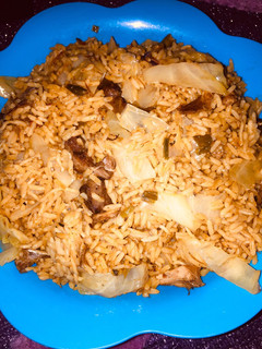 A picture of Jollof rice with cabbage.