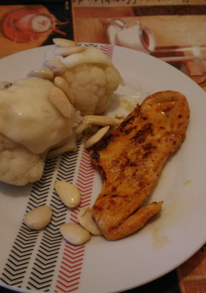 Una foto de Pechuga de pollo al pimentón acompañada de coliflor gratinada