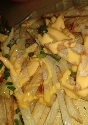 Una foto de Papas fritas con cheddar