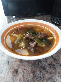 Una foto de Caldo de papas con rajas y carne asada