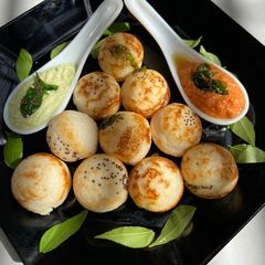 A picture of Paddu with red and green coconut chutney.