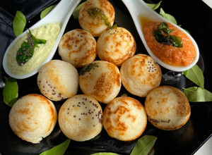 A picture of Paddu with red and green coconut chutney.
