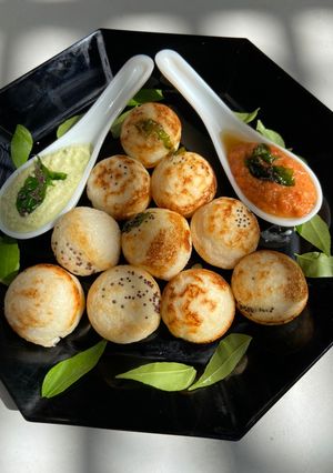 A picture of Paddu with red and green coconut chutney.