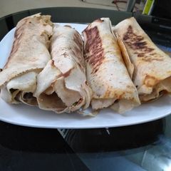 A picture of Pan grilled chicken veggies and avocado wrap.