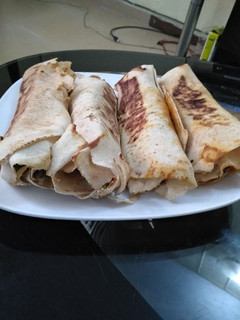 A picture of Pan grilled chicken veggies and avocado wrap.