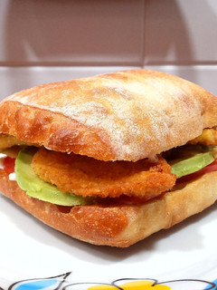 Una foto de Bocadillo de pollo empanado, aguacate y tomate
