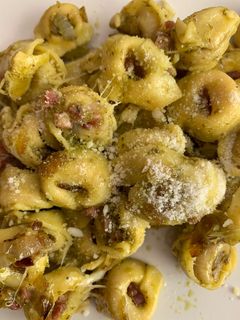 Una foto de Tortelini con cebolla caramelizada y jamón al pesto