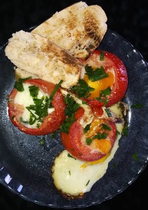 Una foto de Tomates rellenos de huevo!✌️con pan tostado y ajo