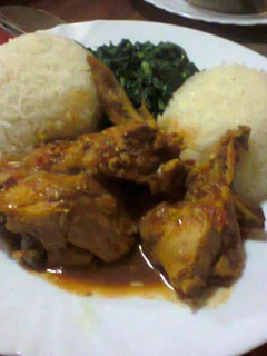 A picture of White Rice served with Curry chicken and vegetables.