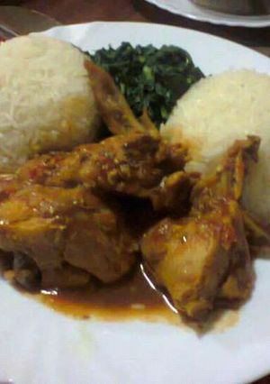 A picture of White Rice served with Curry chicken and vegetables.
