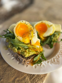 Una foto de Tostadas con aguacate, rúcula y huevo poché
