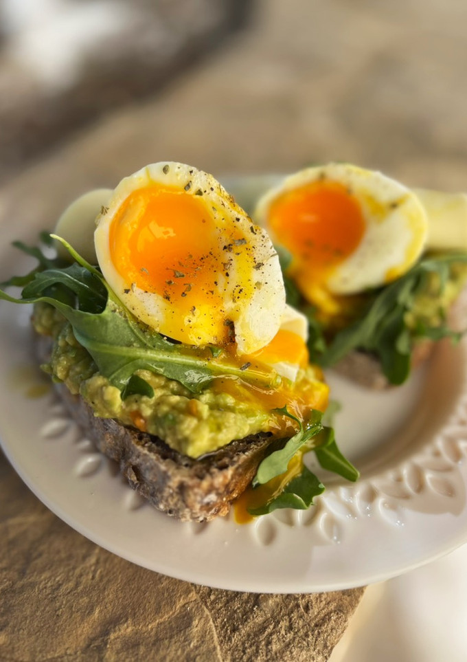 Una foto de Tostadas con aguacate, rúcula y huevo poché