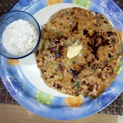 A picture of Aloo Paratha with Masala Yoghurt.