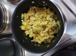 Una foto de Huevos revueltos con papas fritas en cubos, cebolla y arroz