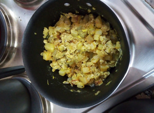 Una foto de Huevos revueltos con papas fritas en cubos, cebolla y arroz