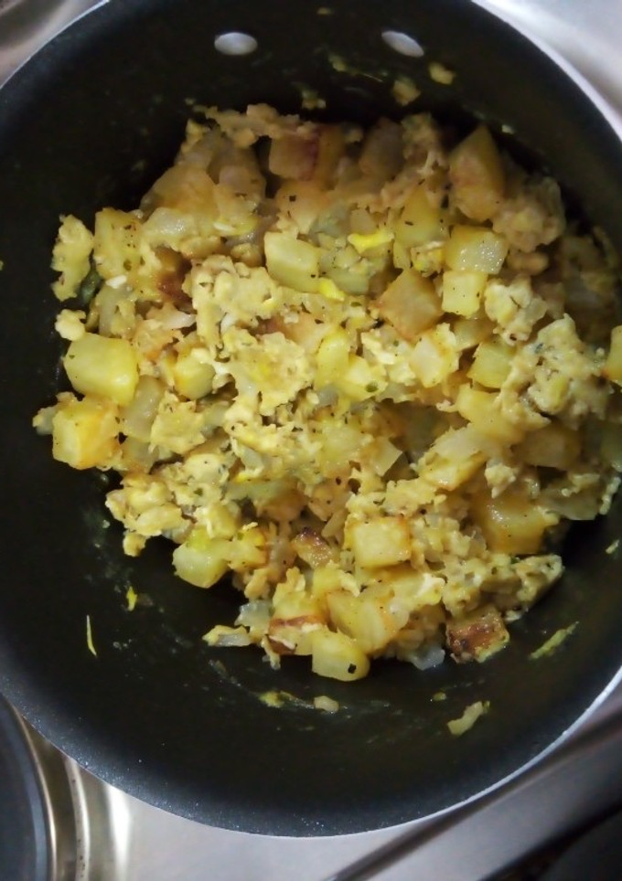 Una foto de Huevos revueltos con papas fritas en cubos, cebolla y arroz