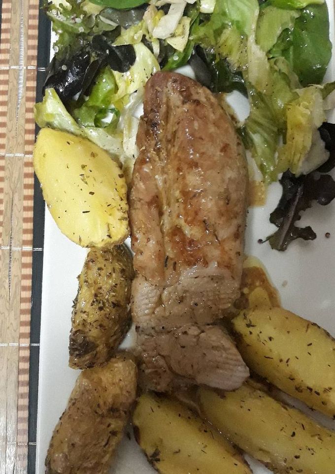 Una foto de Solomillo de cerdo al horno con patatas gajos especiada y asada