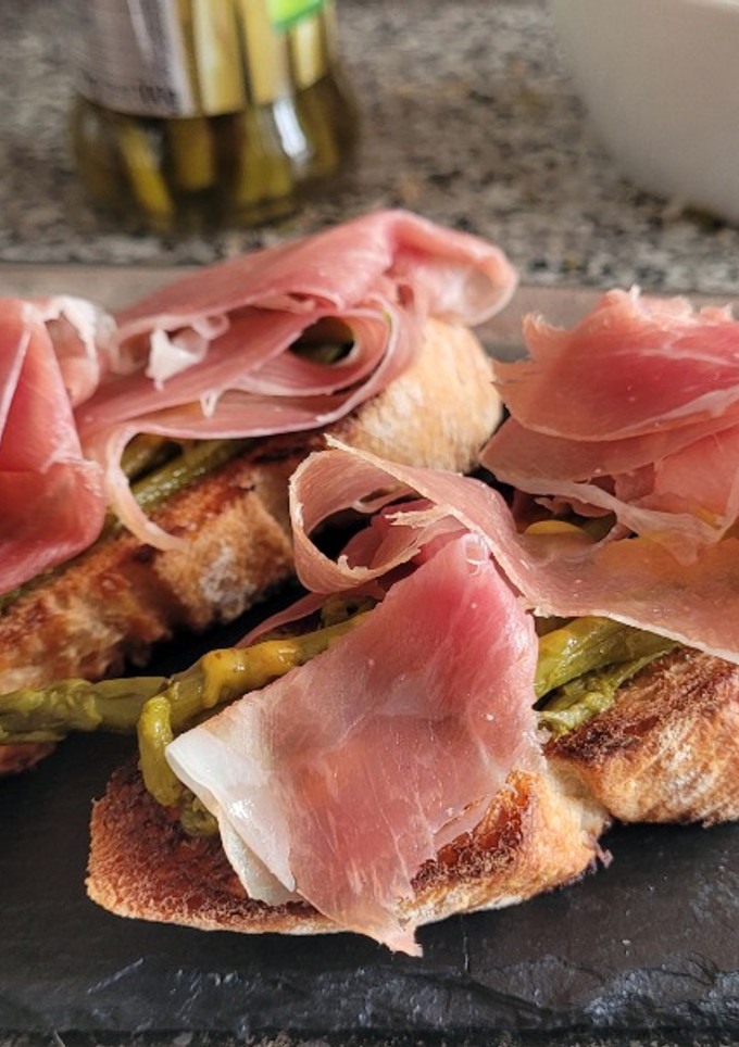 Una foto de Tostadas con espárragos de bote y jamón serrano