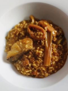 Una foto de Arroz meloso de bacalao, calamar, ajos tiernos y alcachofas