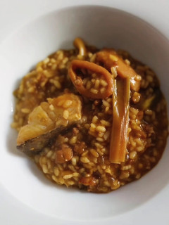 Una foto de Arroz meloso de bacalao, calamar, ajos tiernos y alcachofas