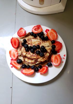 Una foto de Panqueques con fresa y arándanos