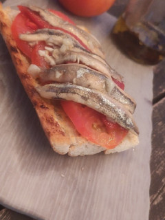Una foto de Tosta de boquerones, tomate y pimientos asados