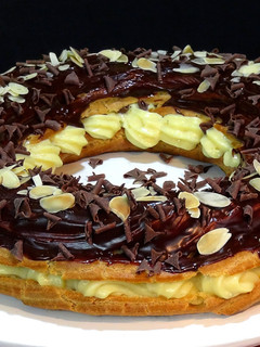 Una foto de Corona de pasta choux rellena de crema pastelera y chocolate. Especial navidad