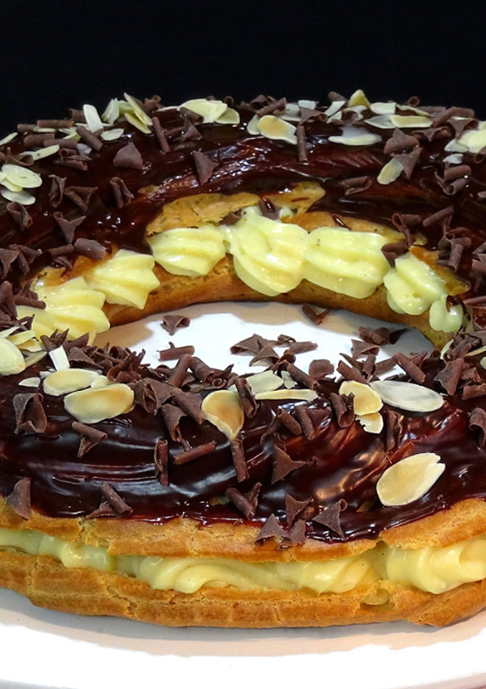 Una foto de Corona de pasta choux rellena de crema pastelera y chocolate. Especial navidad