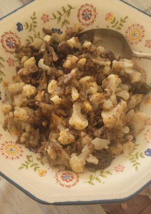 Una foto de Coliflor con salteado de morcilla y cebolla confitada