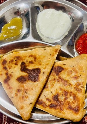 A picture of Aloo Paratha with Curd.