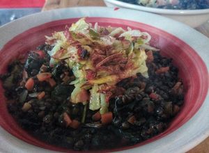 Una foto de Guiso de lentejas negras con crocante de papas y tocino