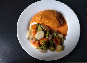 Una foto de Suprema rellena con mousse falso de nuez y verduras papillot