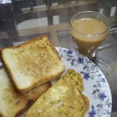 A picture of Cheesy omlete with toasted bread slice.